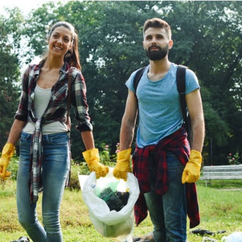 A group of young volunteers help collecting garbage in a public park